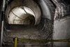 At Aldwych, looking up the crumbling staircase behind the door off Platform 2, next to its overrun tunnel. The top of the staircase leads to a passageway that curves round to a crossroads of more passageways. They were never in public use, as evidenced from the lack of tiling on the walls.