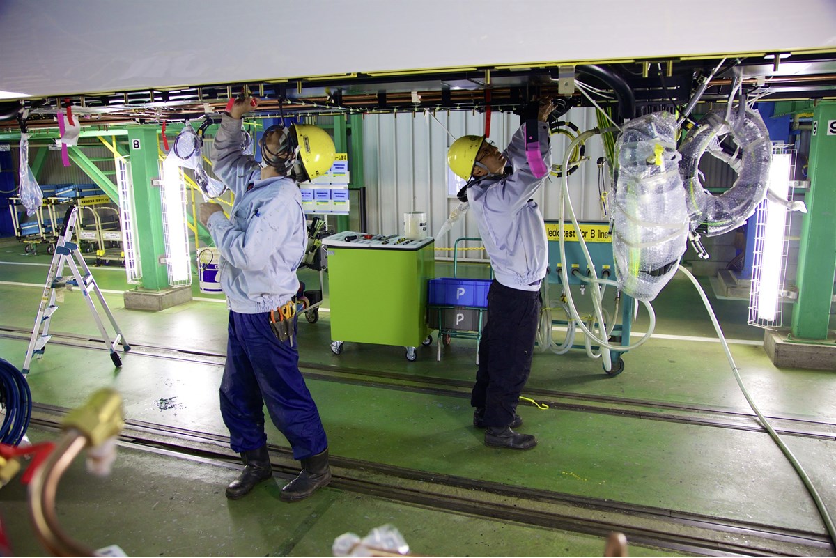 Engineers work on underfloor wiring and pipe runs on one of the part-complete IEP passengers cars. NIGEL HARRIS Engineers working on underfloor wiring
