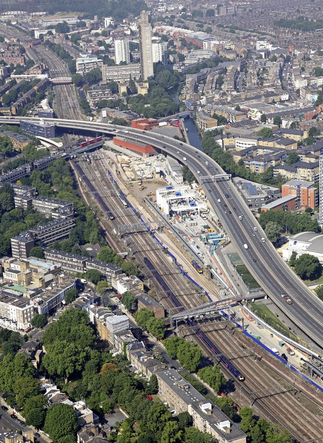 Westbourne Park is perhaps currently best known as a major Crossrail construction site - the first of two tunnel boring machines began work at the Royal Oak portal in March 2012. The area is also dominated by the A40 Westway flyover and the red brick bus depot. A GBRf Class 66 waits in the sidings with a Crossrail spoil train (the contents of which will end up on Wallasea Island in Essex), while First Great Western HSTs and DMUs pass on the Great Western Main Line.