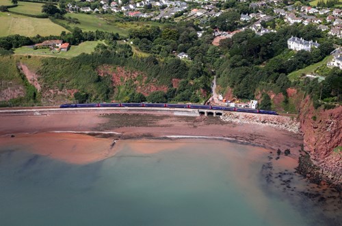 Having left Parson's Tunnel, a First Great Western High Speed Train crosses a small viaduct that carries the railway across Smuggler's Cove. The next station the HST will pass is Teignmouth. First Great Western train approaching Smugglers Cove