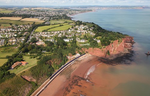 A First Great Western High Speed Train emerges from Parson's Tunnel, which is the last of five between Dawlish and Teignmouth. The tunnel passes beneath Hole Head, and is named after the Parson and Clerk Rocks, which are two stacks in the sea off the Hole Head. Beyond the tunnel is a short viaduct across Smuggler's Lane. First Great Western train emerges from Parsons Tunnel
