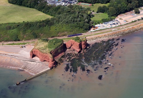 A First Great Western Class 143 bound for Paignton passes Langstone Rock, between Dawlish Warren and Dawlish. The landmark was once connected to the adjacent cliffs, but was severed during the construction of the sea wall railway. First Great Western train passes Langstone Rock
