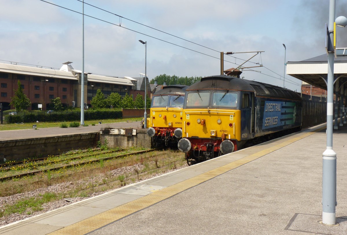 Having arrived with the 1035 from Great Yarmouth, the Class 47 used on a Summer Saturday must wait for the train to leave Norwich for London Liverpool Street before it can be released. The train is booked to leave at 1130. With the London train having departed, Direct Rail Services 47501 Craftsman leaves Norwich, passing classmate DRS 47853 Rail Express.