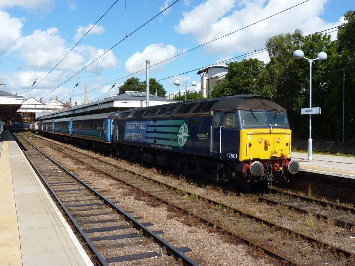 On August 9 2014, the usual duties booked for a Class 47 were replaced by the hired rake of Mk 2s from Direct Rail Services, top and tailed by DRS Class 47s. Normally used during the week, this train replaced the through trains from London, but ran in the same paths. As well as the 1035 and 1310 Great Yarmouth-Norwich, and 1203 and 1450 returns, the '47s' were also used additionally on the 1625 Great Yarmouth-Norwich, which is the path used for the empty coaching stock to Norwich from Yarmouth. On August 9 2014, DRS 47501 Craftsman waits to work the 1310 to Yarmouth.