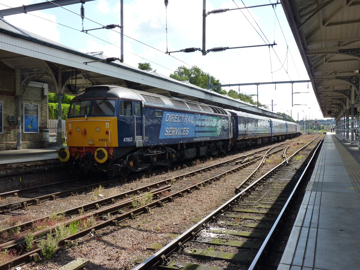 On August 9 2014, Direct Rail Services 47853 Rail Express waits to trail the 1310 to Great Yarmouth, which was hauled by DRS 47501 Craftsman. The 'short set' as it is known by locals, was used as the usual rakes of Mk 3s that are used on through trains to and from London to the coast were not available.