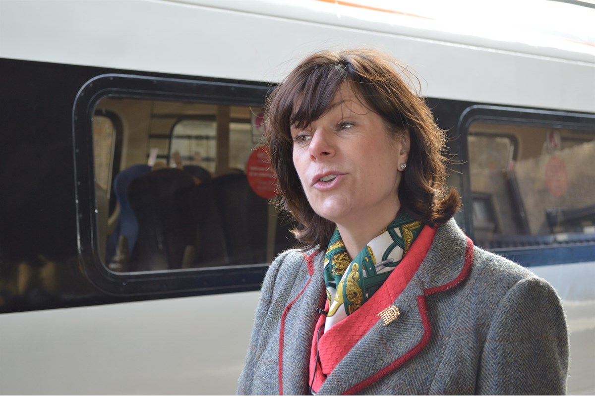 Rail Minister Claire Perry speaks to the media with the newly-rebranded Class 91/Mk 4 set in the background.