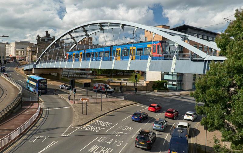A train… straight into town. That’s the promise of tram-train, and one that more UK cities are interested in adopting. A Stadler Class 399 crosses the bowstring bridge over Park Square and Commercial Street in Sheffield. ALAMY.