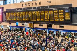 Huge crowds at London Euston railway station concourse looking at the departure boards. London, England. ALAMY.