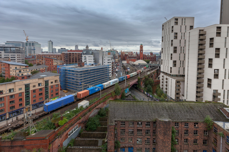 Freightliner container freight train passing Manchester Oxford Road on the congested two-track railway through Manchester Castlefield. ALAMY.