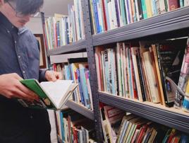 A young library user browses the collection.