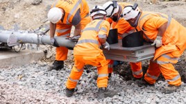 Rail engineers lift a new signal into place